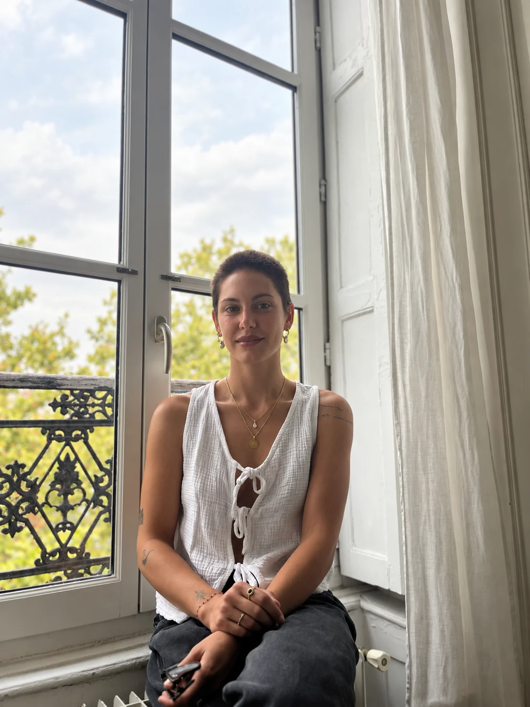 Emma, sophrologue de Nafas Flow, assise près d’une fenêtre en lumière naturelle